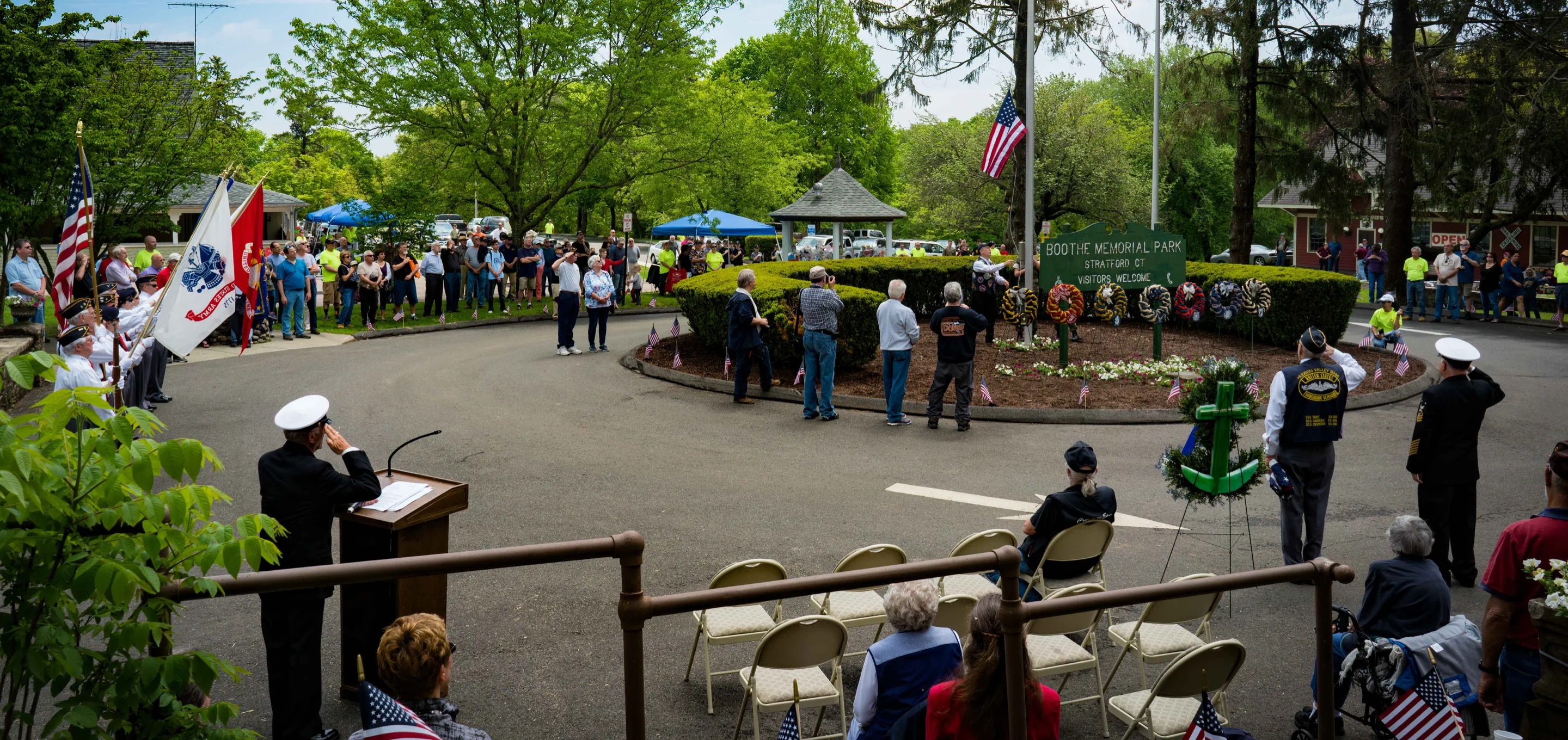 Opening Day ceremony with visitors gathered around the Boothe Memorial Park entrance
