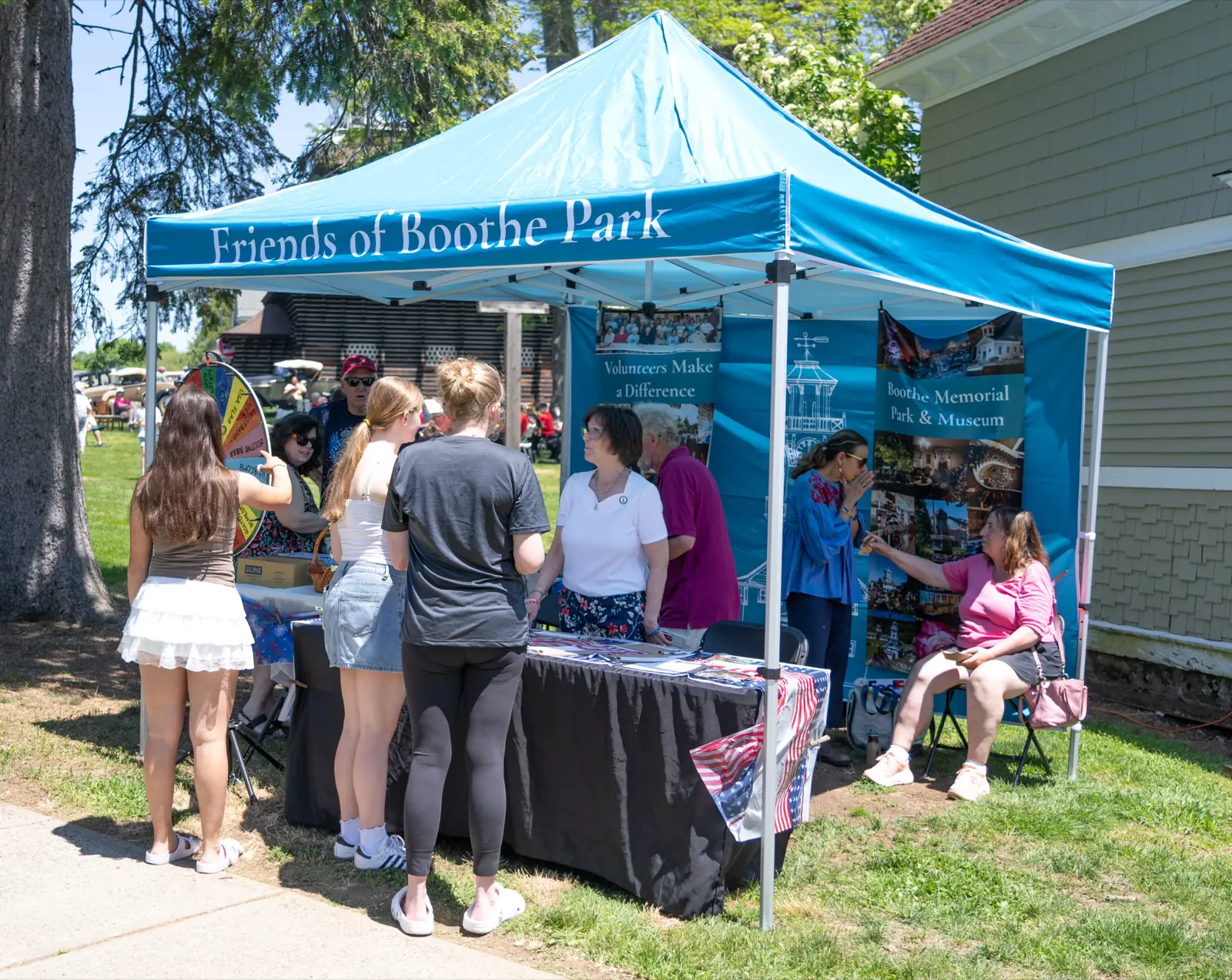 Friends of Boothe Park volunteers talking with visitors at their tent on Opening Day