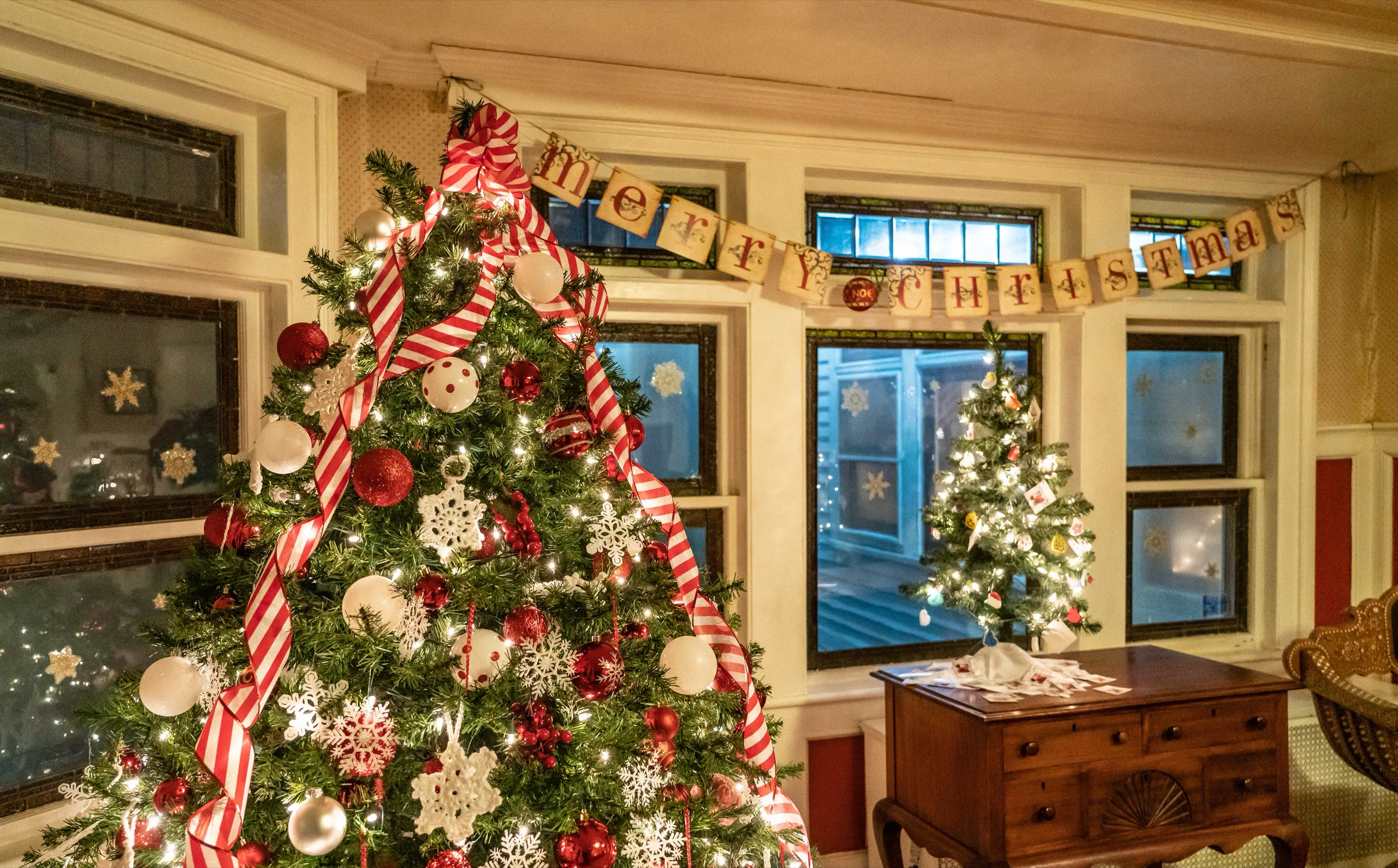 A red-and-white candy cane themed Christmas tree displayed inside the Boothe Homestead
