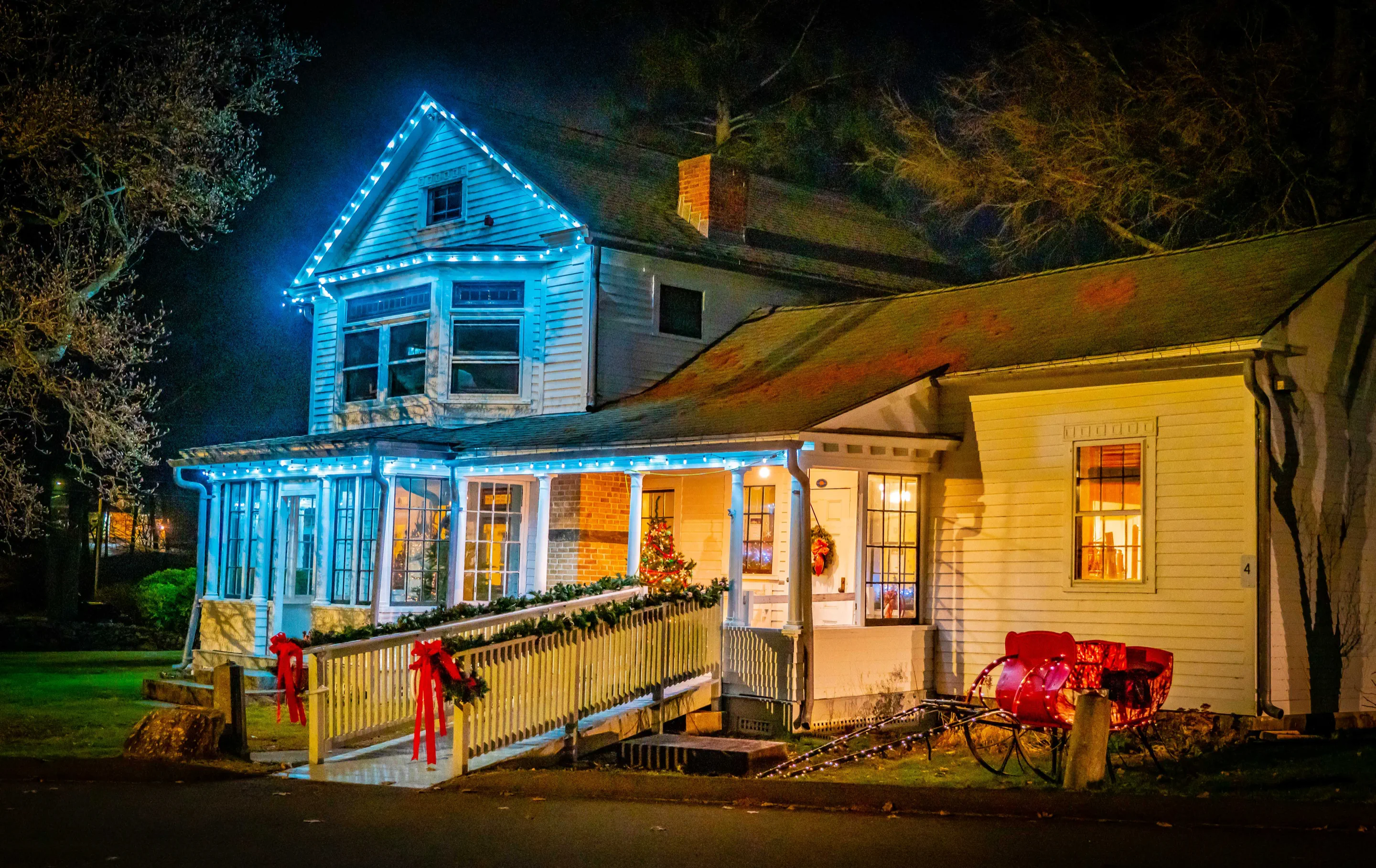 The Boothe Homestead illuminated with Christmas lights and holiday decorations at night