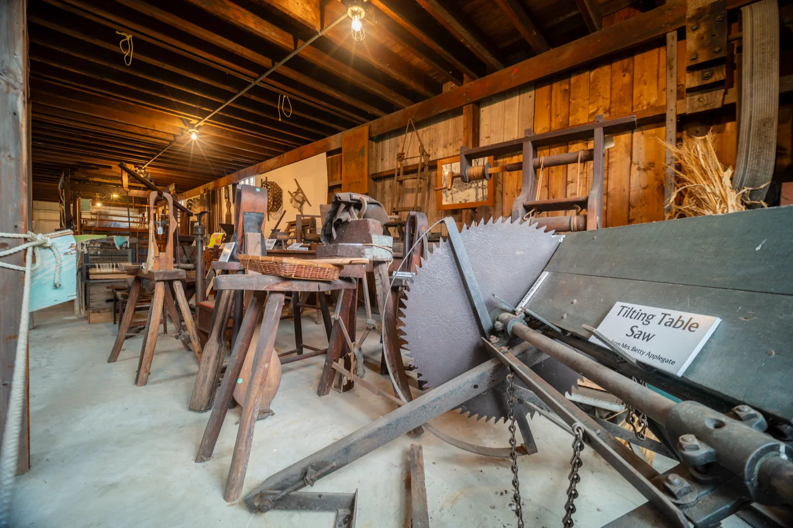 Antique tilting table saw and woodworking equipment displayed inside the Americana Museum