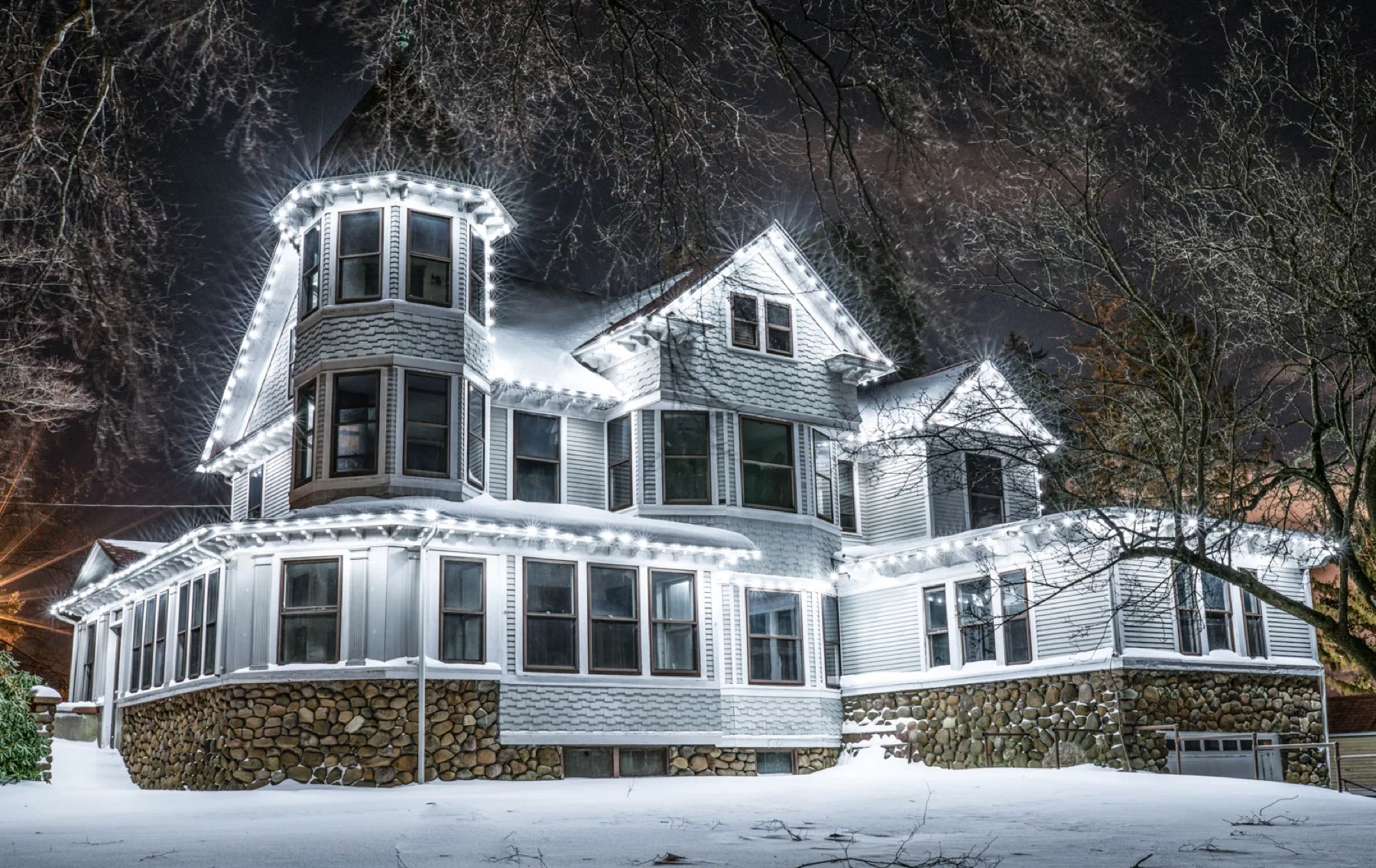 Stephen Boothe House outlined in holiday lights after a snowfall