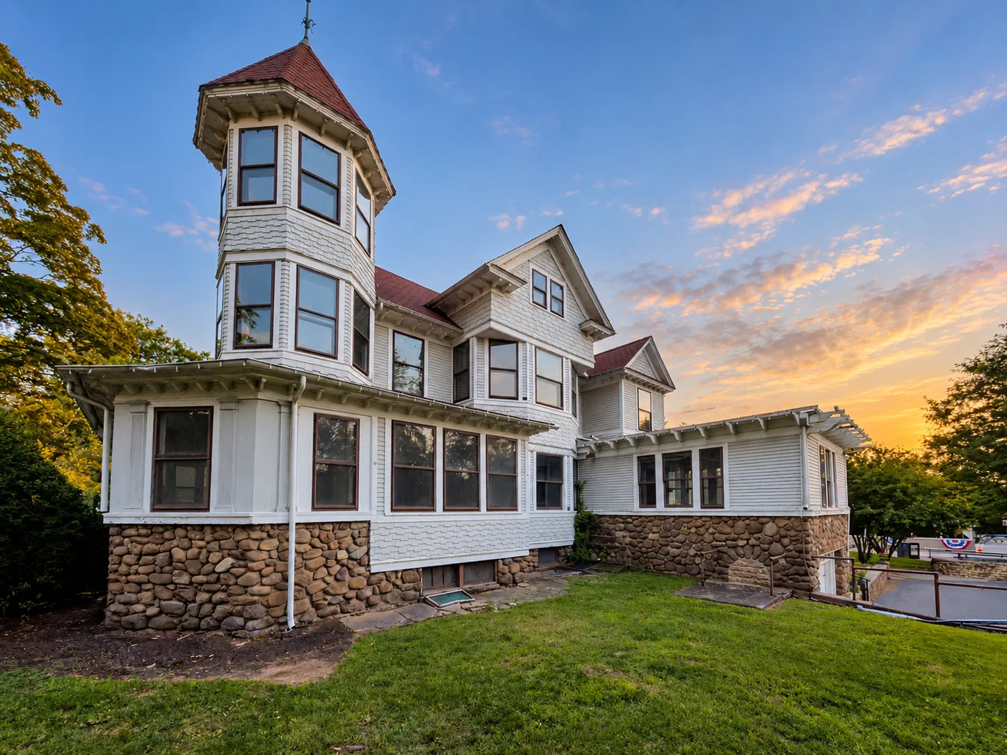 Stephen Boothe House with its corner turret and fieldstone foundation at sunset