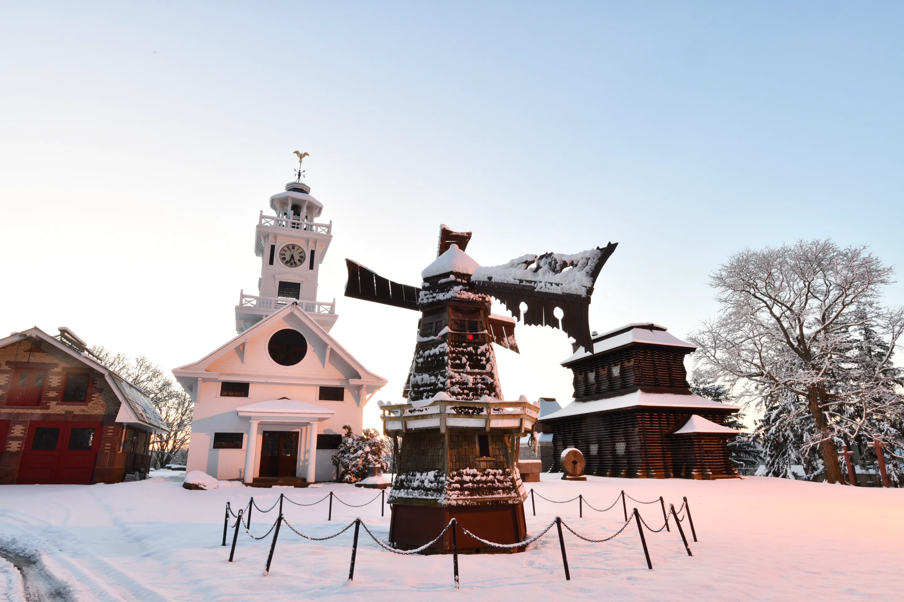 The miniature windmill, Clocktower Museum, and Redwood Building after a snowfall