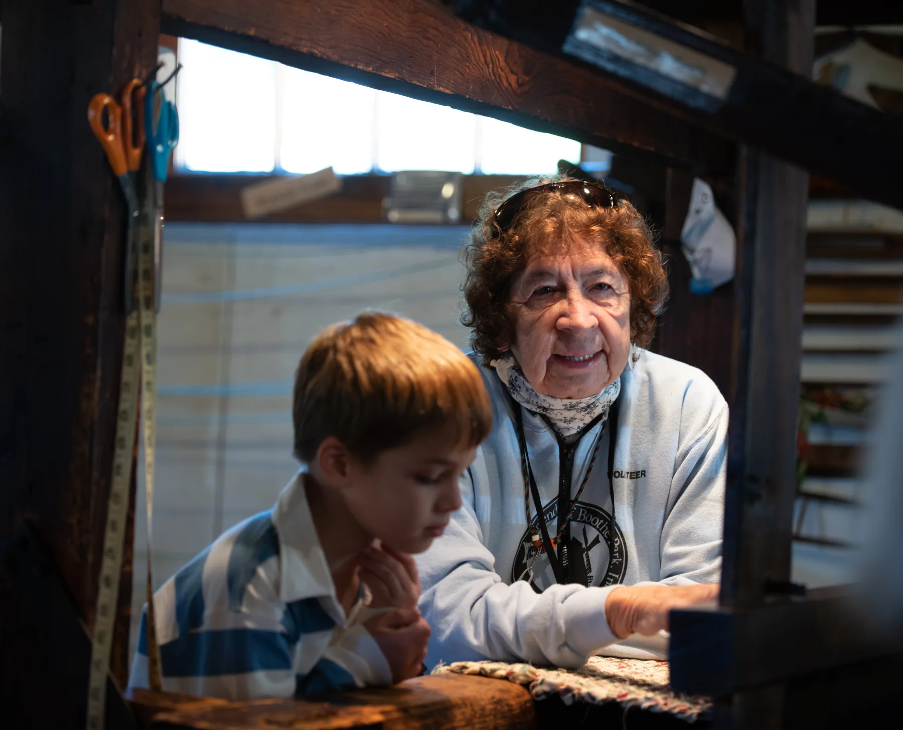A Boothe Park volunteer and young visitor looking at an exhibit together